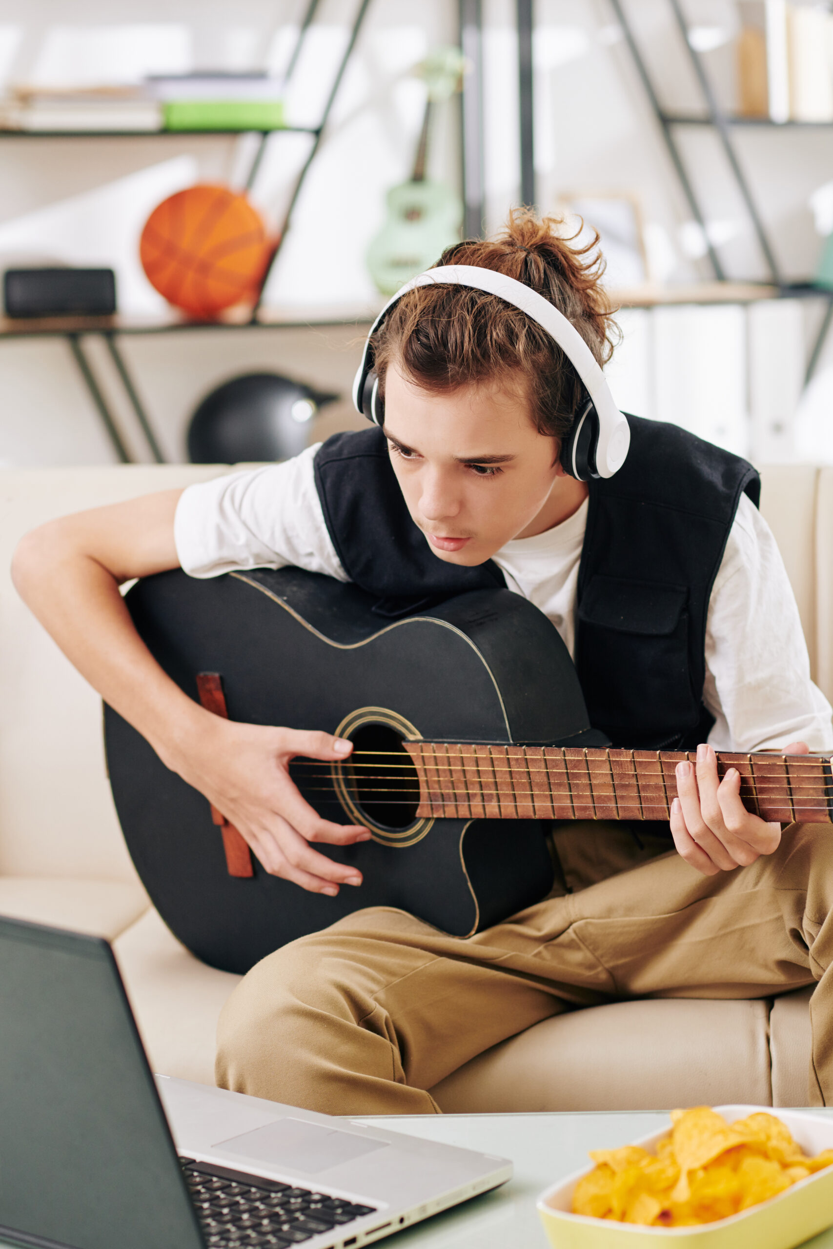 Boy following chords on laptop